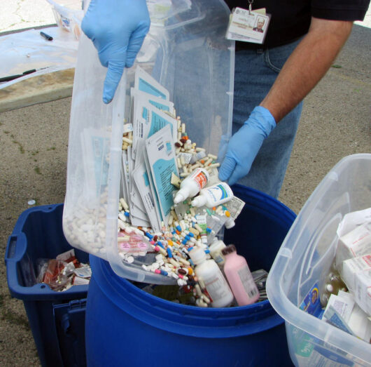 Proper disposal of unwanted medications into a collection bin