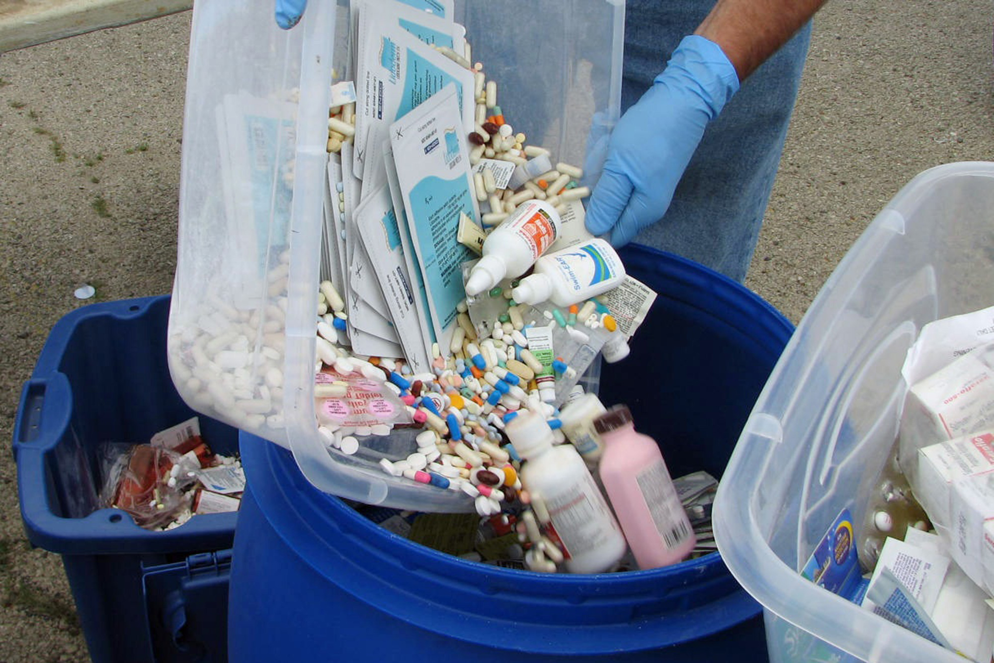 Proper disposal of unwanted medications into a collection bin